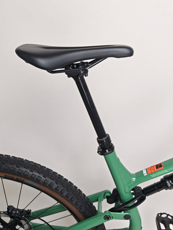 The 2023 Canyon Neuron 7 Full Suspension Bike parked in natural light showing its beautiful Forest Green frame, Large size, in Very Good Condition.