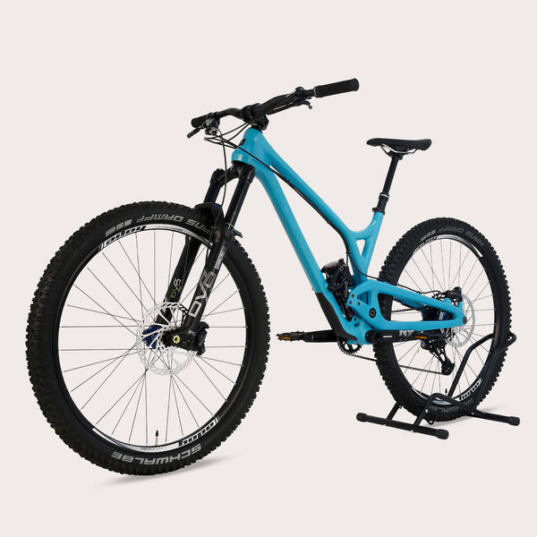 Evil Offering V1 carbon fiber full suspension bike in blue color, standing on a bike stand.