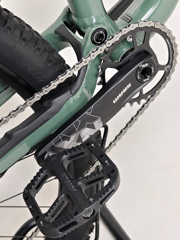 Image capturing the used Specialized Stumpjumper Comp Alloy parked beside a mountain trail.