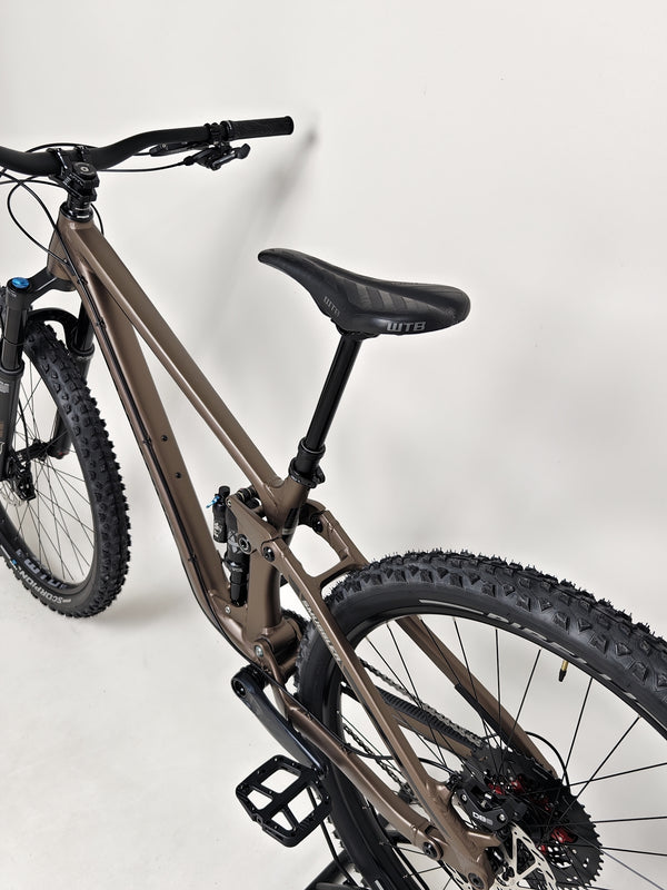 View of the bike tires and wheels on the Transition Smuggler NX 2024 in medium for outdoor performance.