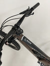 Close-up of the front fork and shock details on the Orange ALPINE 6 mountain bike.