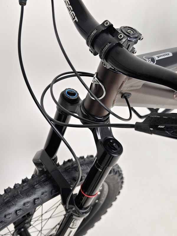 Action shot of the Orange ALPINE 6 mountain bike navigating through challenging terrain.