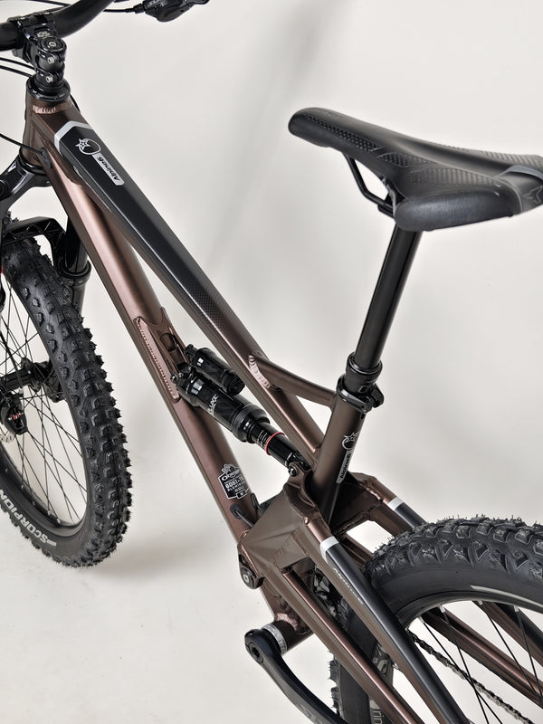 The Orange ALPINE 6 Full Suspension Mountain Bike displayed against a sunset.