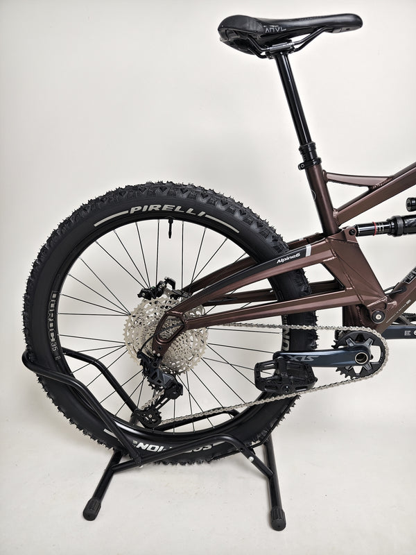 Close-up of the rear suspension and brake system on the Orange ALPINE 6 mountain bike.