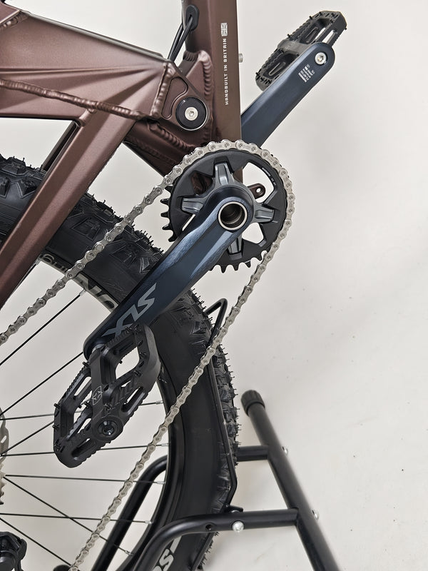 The Orange ALPINE 6 mountain bike in action, climbing a steep trail.