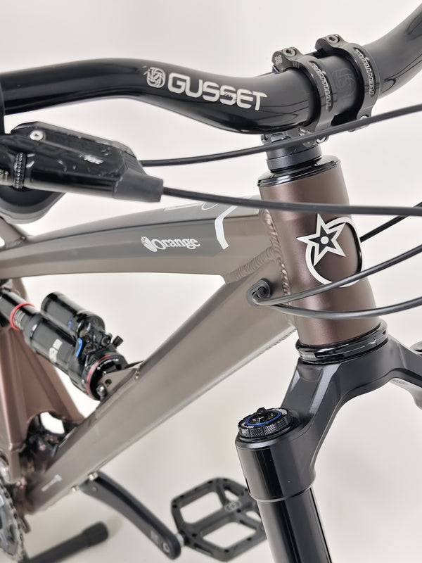 The Orange ALPINE 6 mountain bike's sleek design viewed from the rear end.