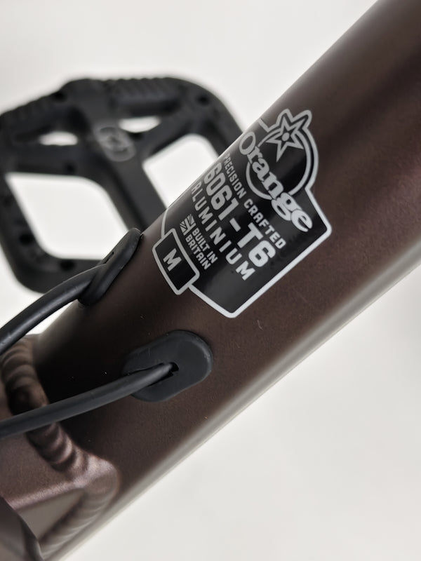 The Orange ALPINE 6 mountain bike laying next to a bike repair station.