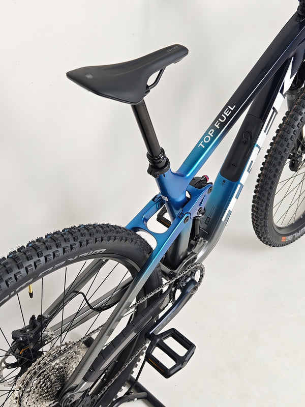 Trek Top Fuel 9.7 2022 CARBON bike set against an outdoor landscape, emphasizing its mountain bike prowess.