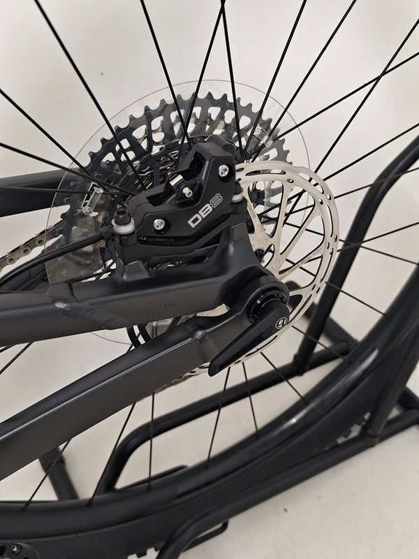 Trek Top Fuel 8 GX AXS 2024 resting under a tree, emphasizing its suitability for outdoor adventures.