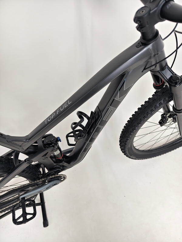 Trek Top Fuel 8 GX AXS 2024 rear view emphasizing the bike's gearing and wheel alignment.