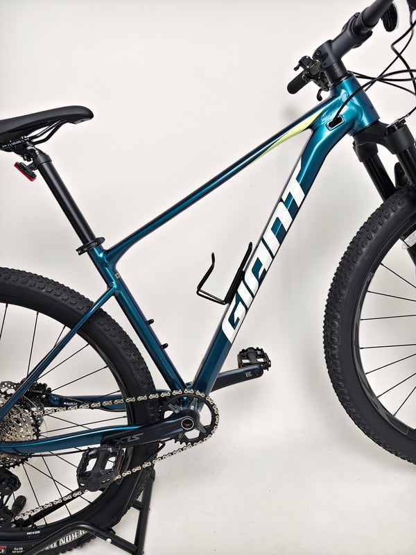 Side view of the Giant XTC SLR 29 1 Mountain Bike 2024 in a scenic background.